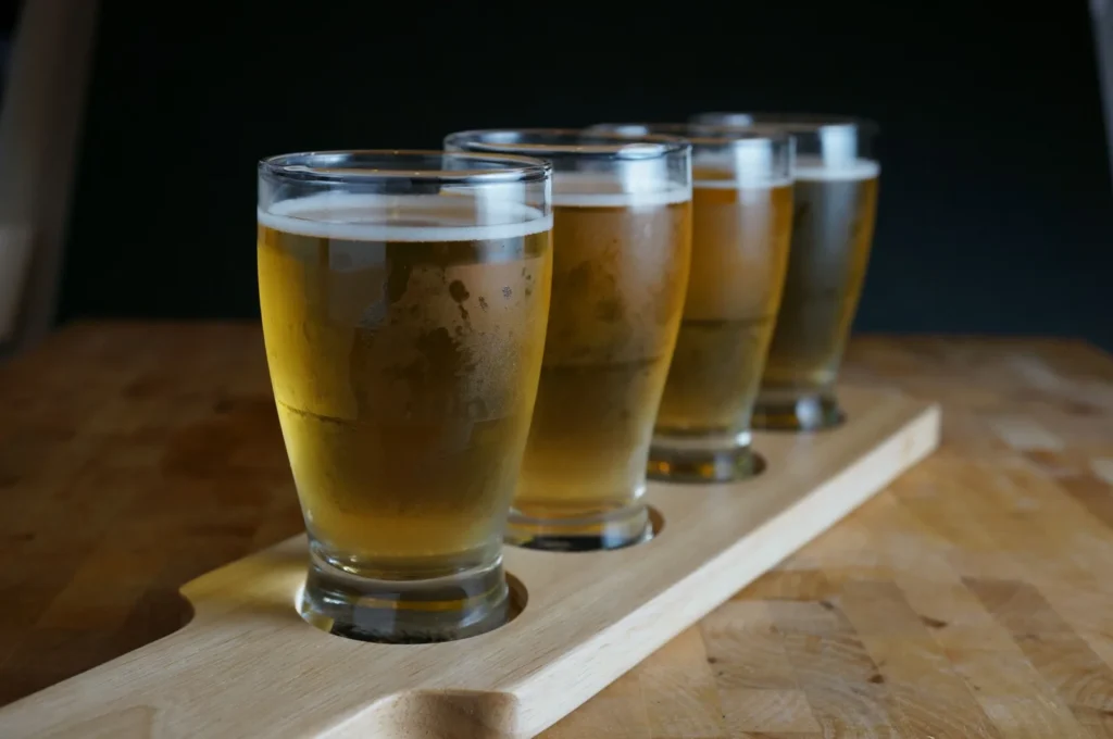 Selección de cervezas servidas en vasos de degustación sobre una tabla de madera